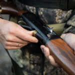 close-up of person holding hunting rifle