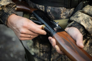 close-up of person holding hunting rifle