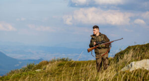 hunter with rifle on a plain