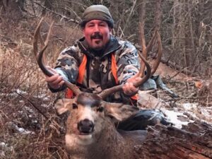 A man poses with an antelope he caught