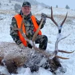 A man poses with the moose he has taken