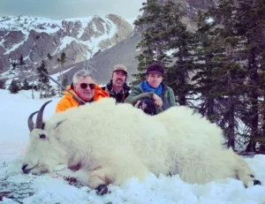 Three Elk Ridge Outfitters hunters pose with a Mountain Goat